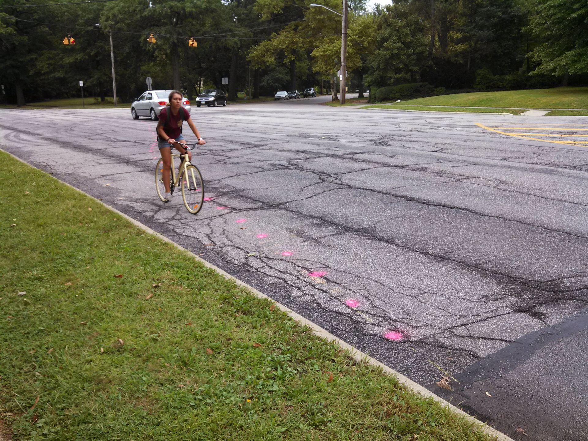 A young woman on a bike cycles through the wide intersection of Edgehill and Overlook roads before "complete streets" improvements to narrow the lanes.