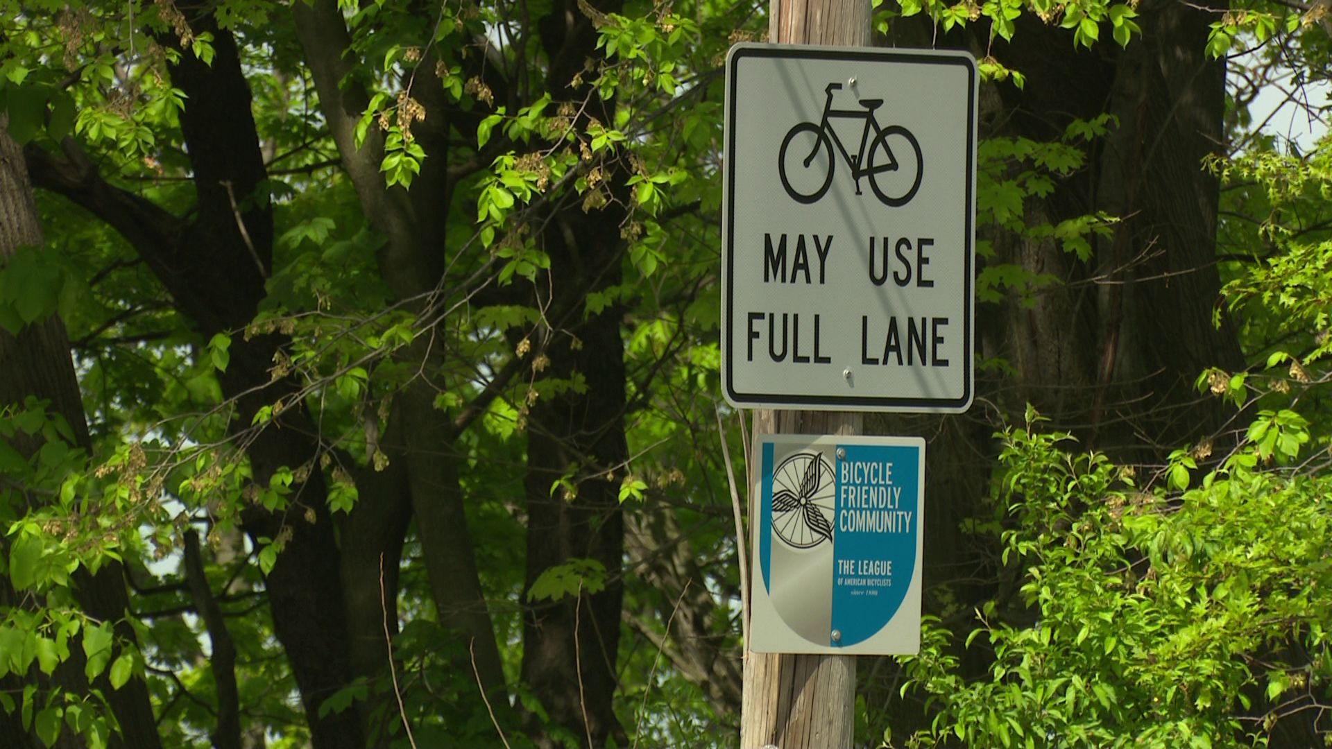 A traffic sign that tells drivers that bicyclists may use the full lane and a second sign noting that Cleveland Heights is a bicycle-friendly community.