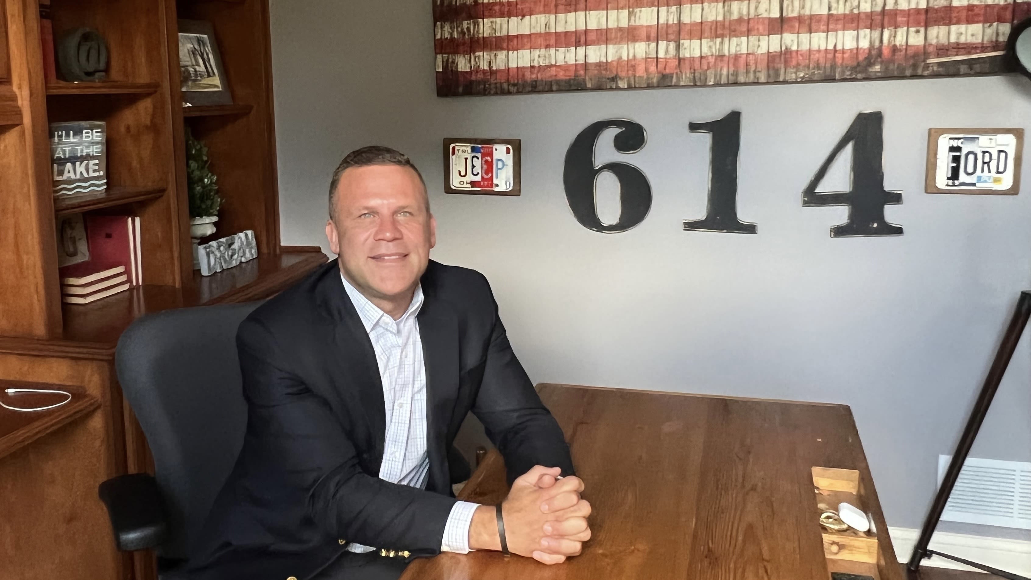 Mike Gonidakis sits at his desk in his home office where the 614 area code of Columbus decorates his wall.