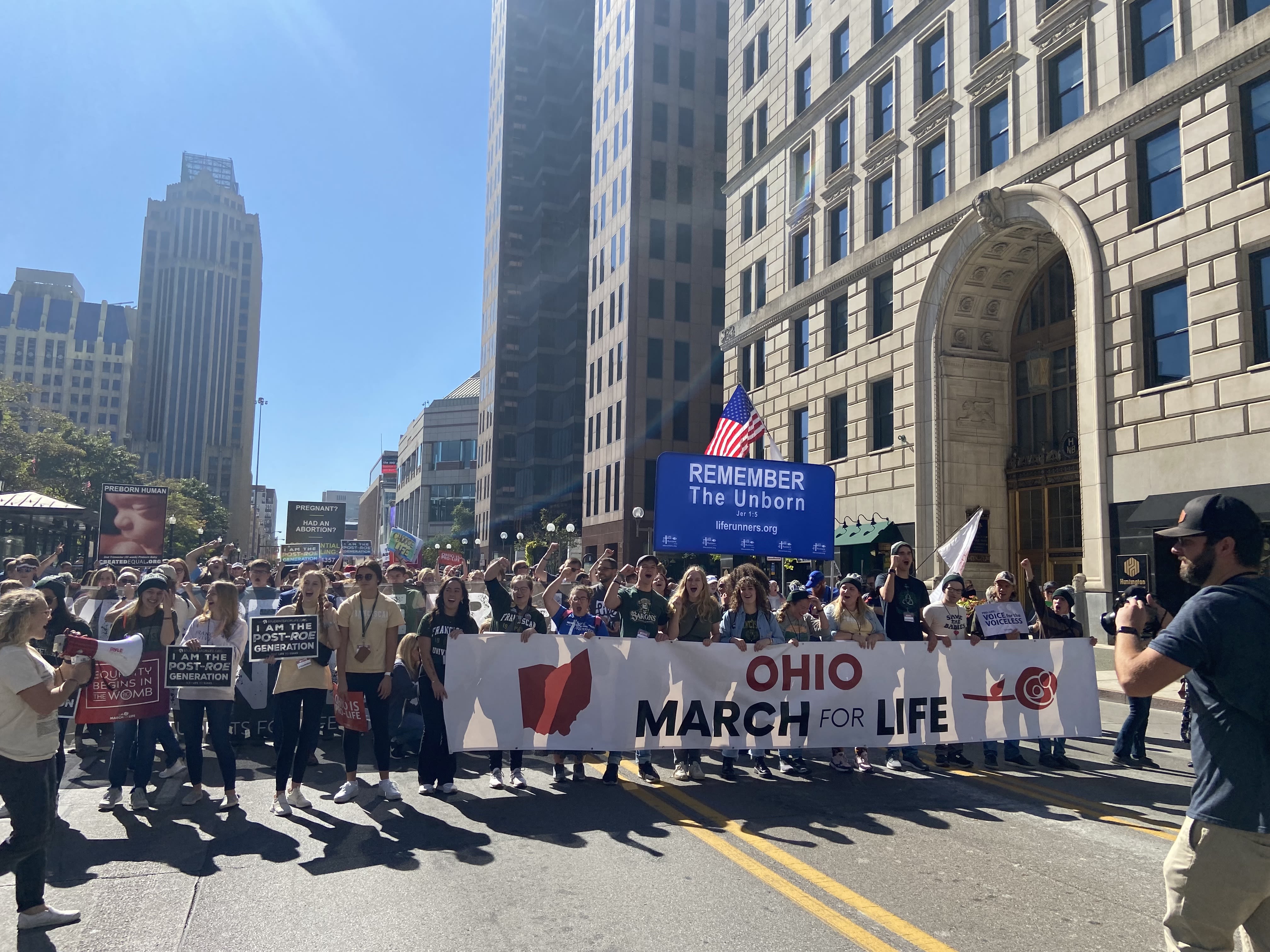 Demonstrators carrying a sign reading "Ohio March for Life" parade down a street in Columbus on Oct. 5, 2022.