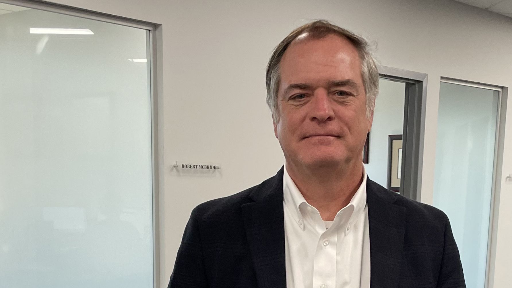 Robert Bilott stands in the hallway outside an office.