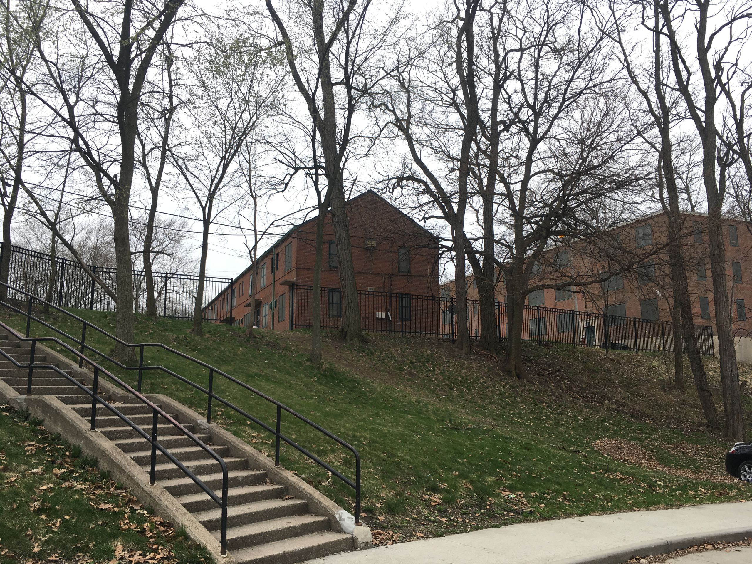 A photo shows brick buildings and stairs at Woodhill Homes.