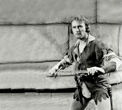 Swashbuckling movie idol Errol Flynn holds his sword.