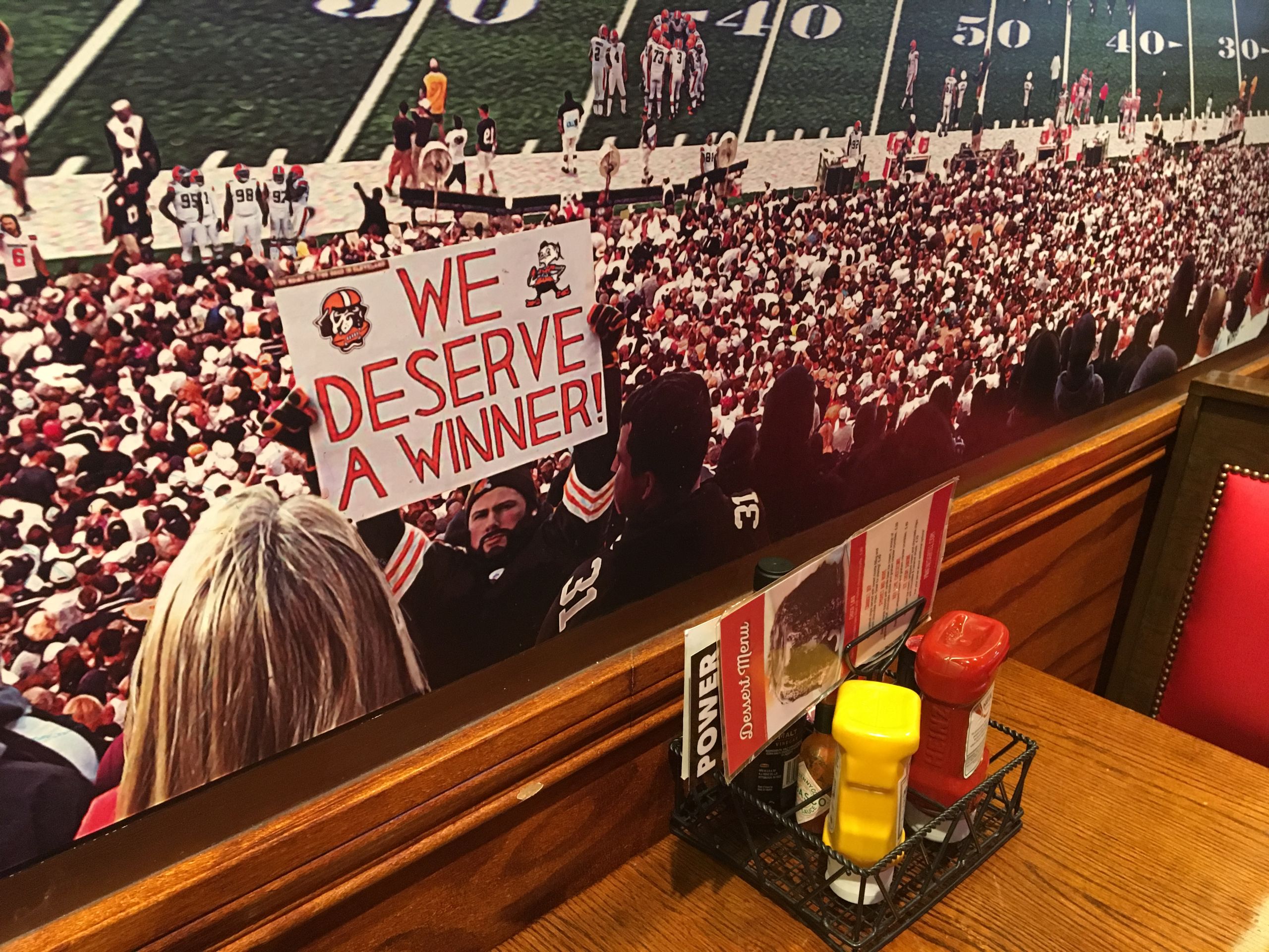 Rivera-Resto did a mural for the Westlake Panini's that depicts a crowd of Browns fans, including someoine holding up a sign that says "We deserve a winner."