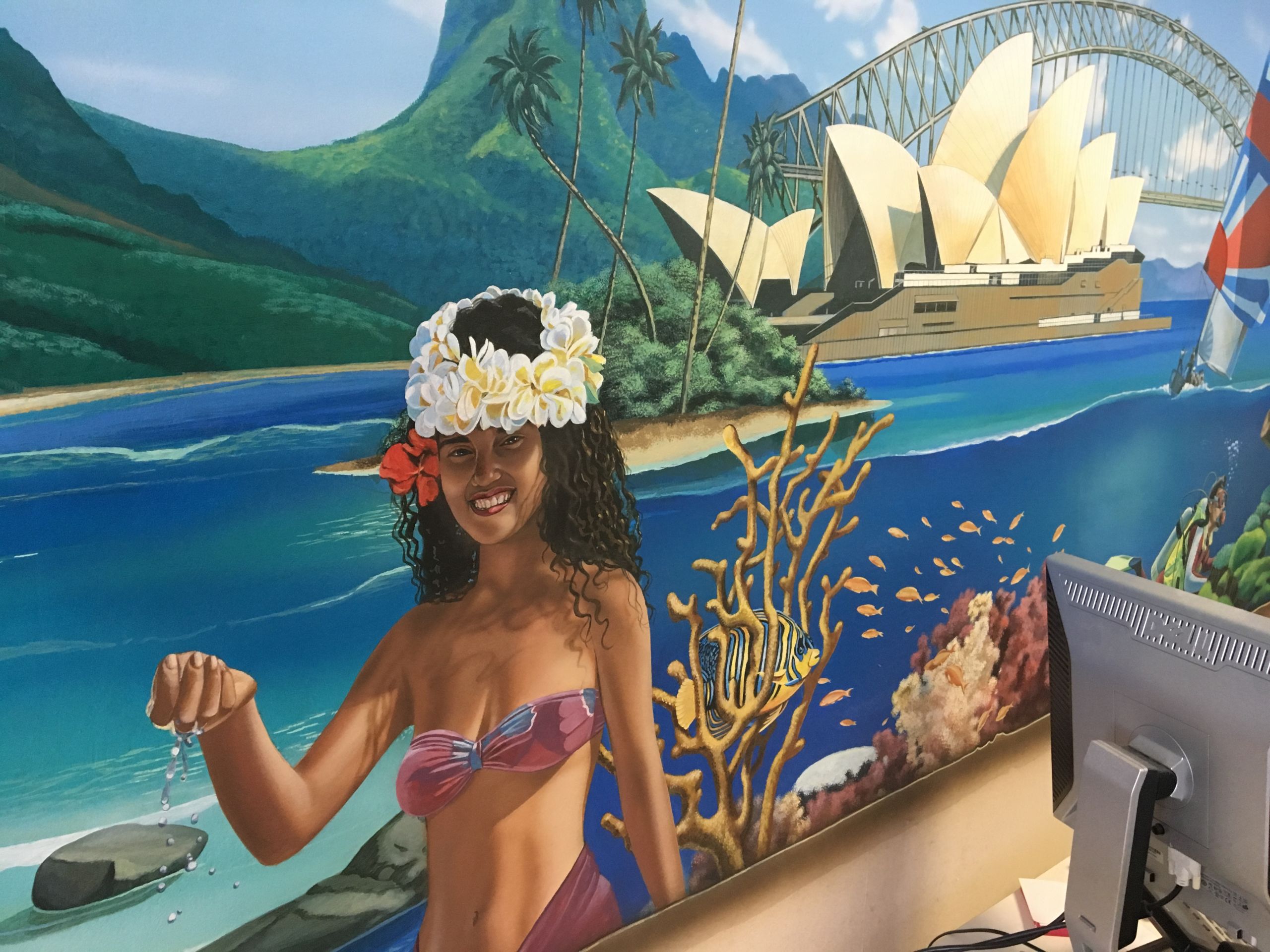 Rivera-Resto did a Pacific Ocean-themed mural at Panorama Travel in Lakewood that includes fish swimming in the coral, the Sydney Opera House, and a woman wearing a ring of flowers on her head.