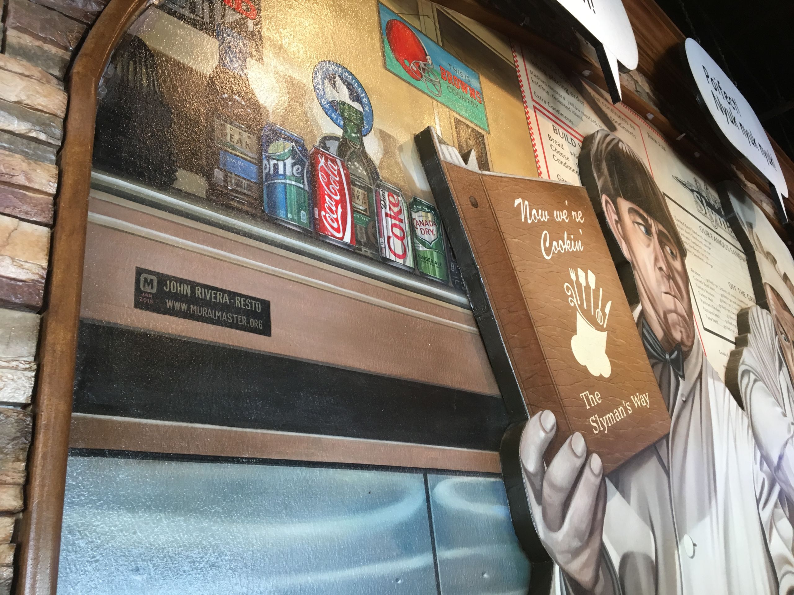 Rivera-Resto works in his signature as a refrigerator nameplate on his tribute to the Three Stooges at Slyman's Deli in Independence.