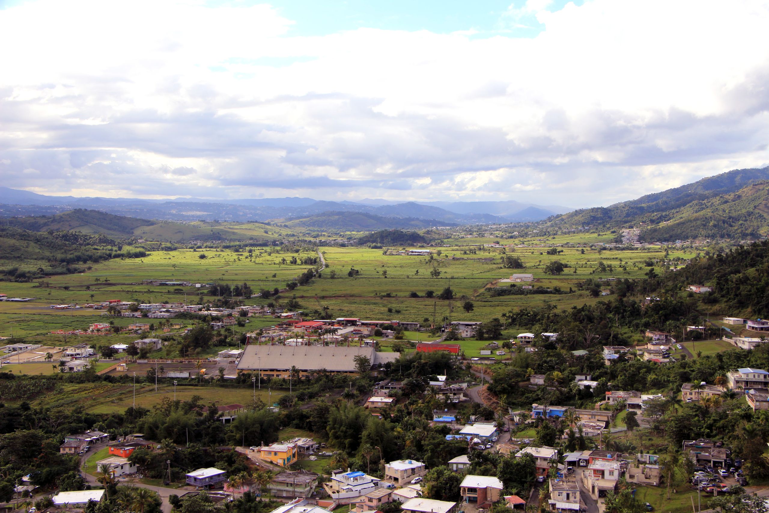 Homes and churches are spread across a green valley back at Rivera-Resto's childhood home in Las Piedras, Puerto Rico.
