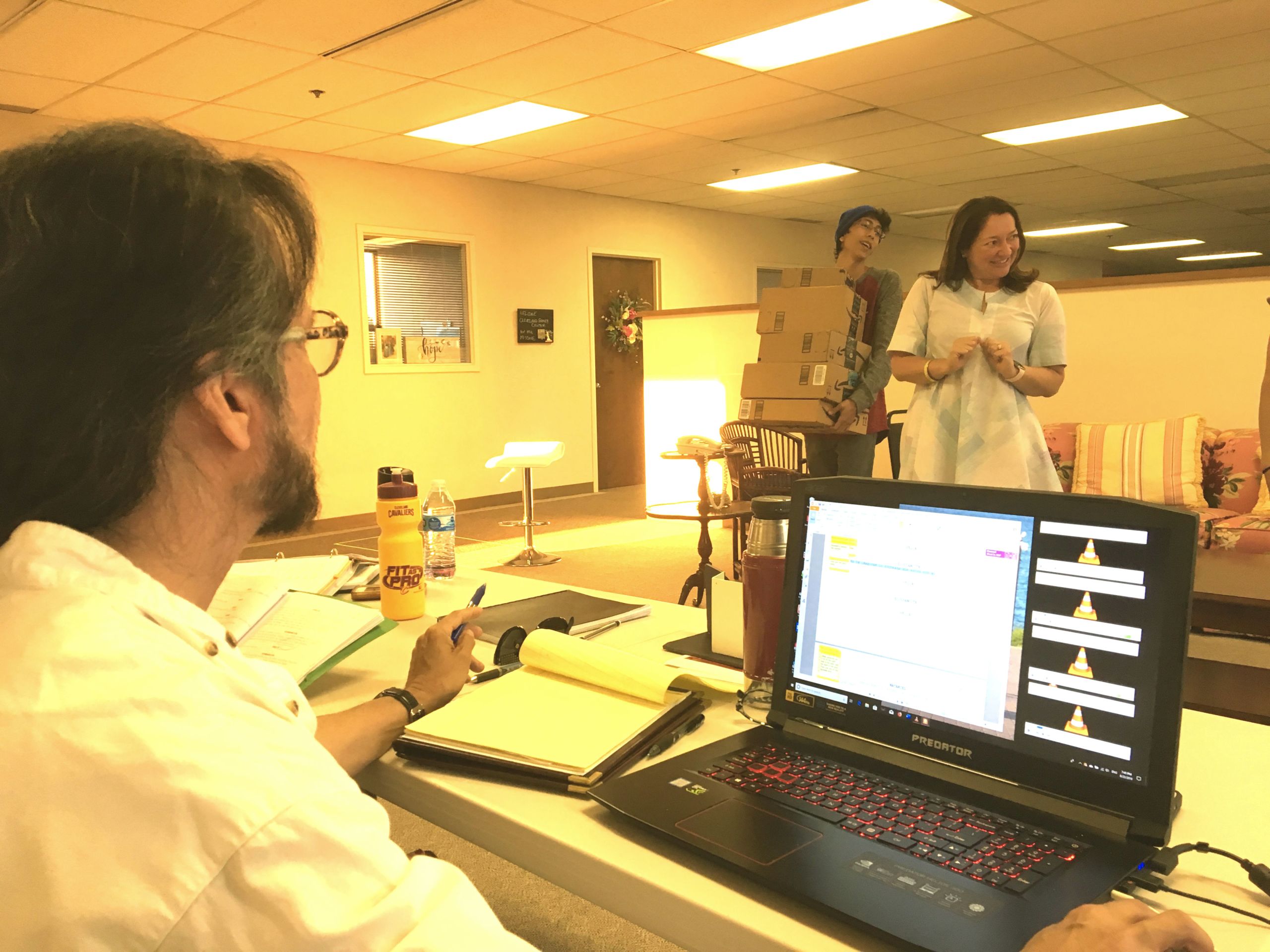 Rivera-Resto directs a scene in a LatinUs Theater Company play, following the script on a laptop and jotting notes on a legal pad.