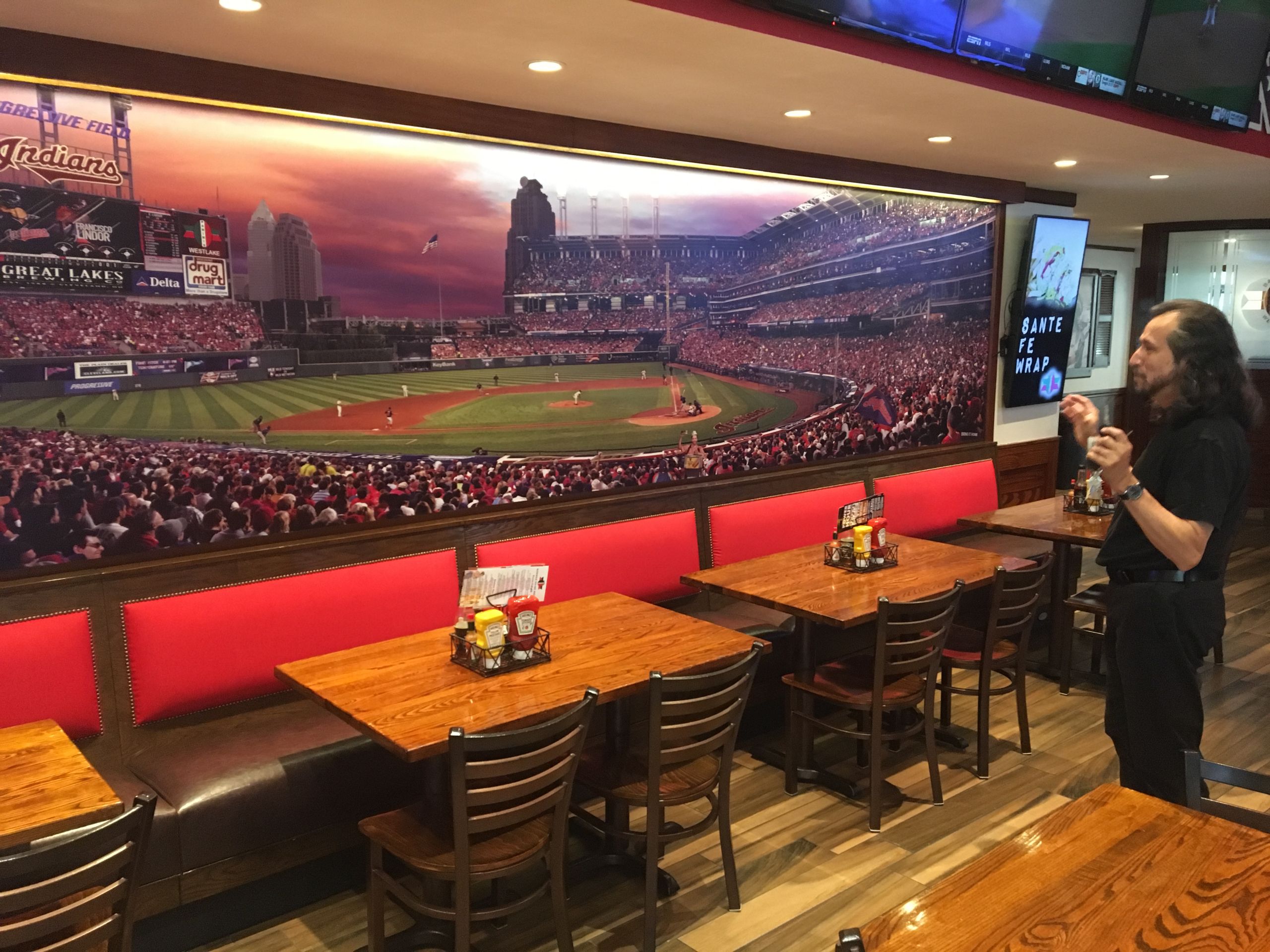 Rivera-Resto's examines his mural of Progressive Field at Panini's in Westlake 